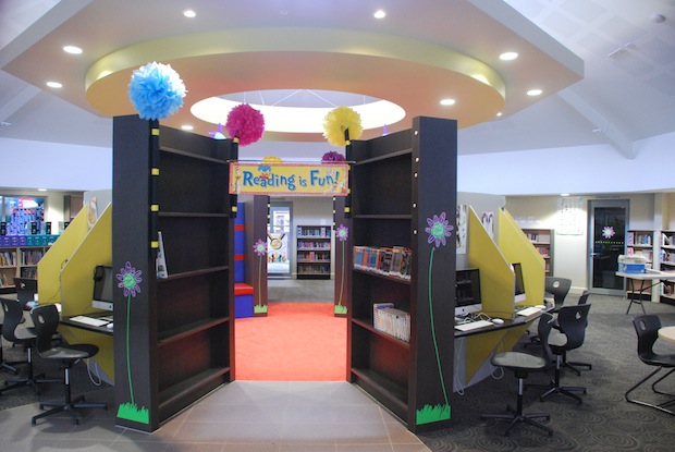 Bright school library entrance with reading displays, bookshelves and a central walkway inviting students to explore reading