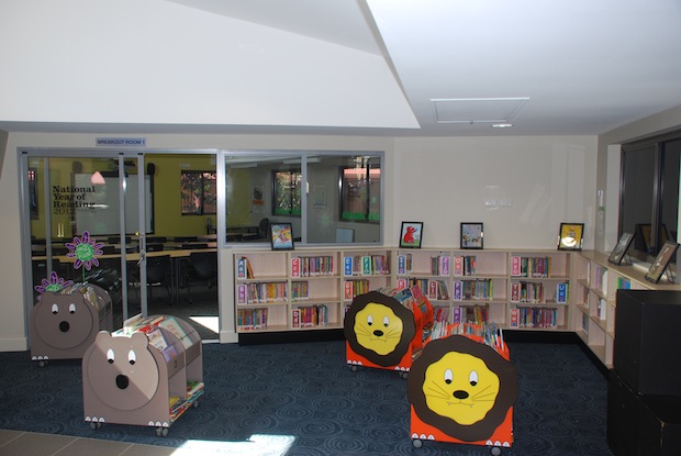 Junior library area with low bookshelves, themed displays and colourful seating for early years reading