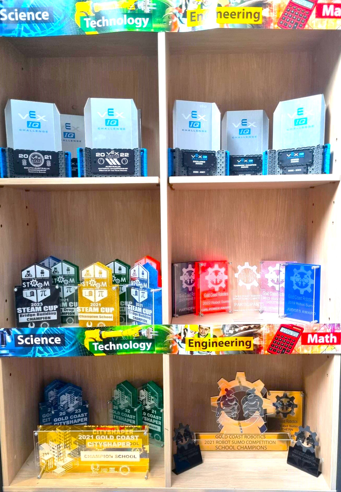 Display cabinet of robotics and STEM competition awards highlighting school achievements in technology and engineering
